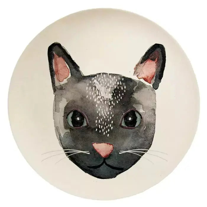 Illustration eines grauen Katzengesichts mit einem weißen Fleck auf der Stirn, runden Wangen, schwarzen Ohren, rosa Nase und Schnurrhaaren vor einem hellen Hintergrund, gestaltet als Nuukk-Tellerdekoration.
